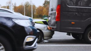 Car rear-ended into a van on a busy road, showing fault in an Alberta rear-end collision under provincial insurance rules.